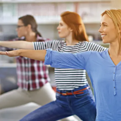 Three woman perform exercises. 
