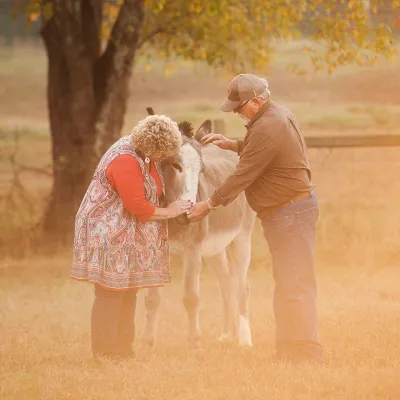 Jim and Ginger Jones on their farm with a donkey