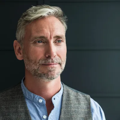 An older man in a vest. 