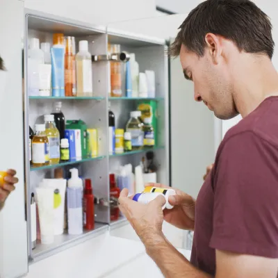 Man cleaning medicine cabinet