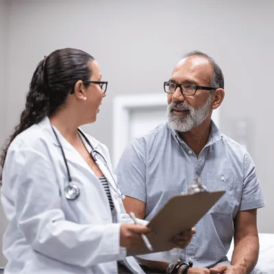 A middle-aged man talking to a female doctor.