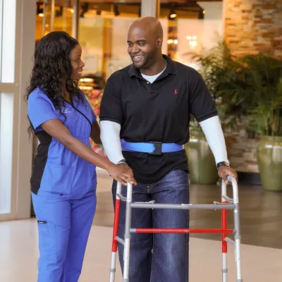 Nurse helping patient during therapy session. 