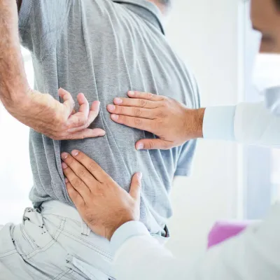 A man experiencing back pain at the doctor's office. 
