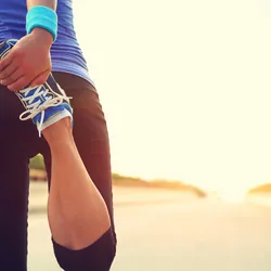 A runner stretches her leg.
