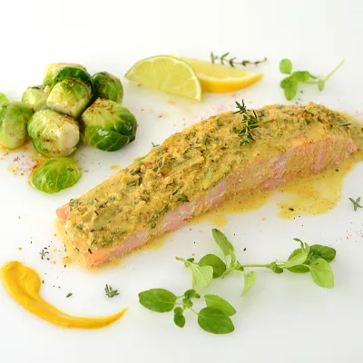 Herb-crusted salmon filet with Brussels sprouts and herb garnish
