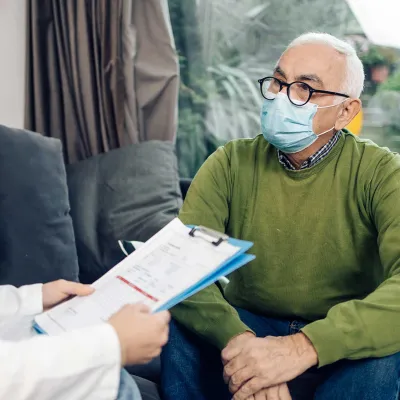 A senior gentleman sitting with his doctor