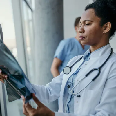 A female doctor looking at a body scan image.