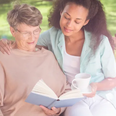 Two women reading a book together