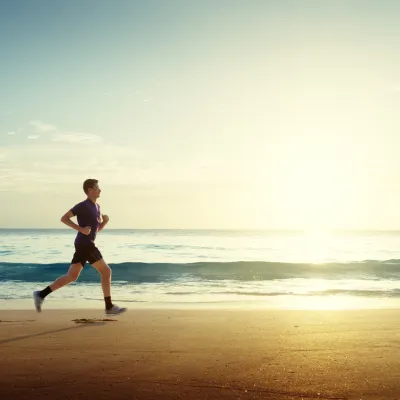 Person running on the beach on a sunny day