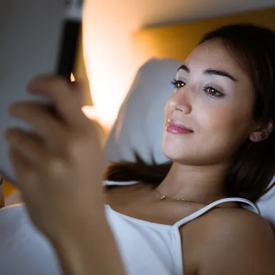 Woman in bed using her tablet