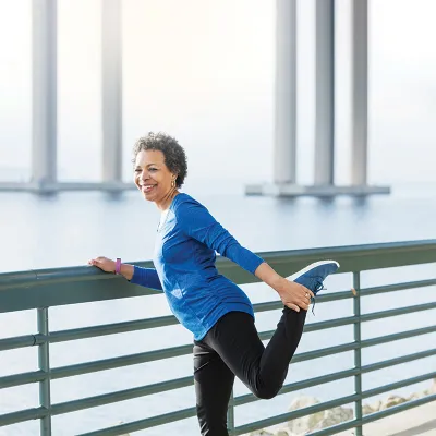 Woman stretching during run on a bridge