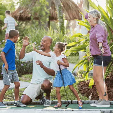 family playing mini golf during spring break