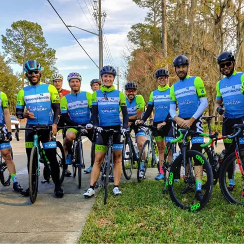A group of cyclists standing in front of the camera