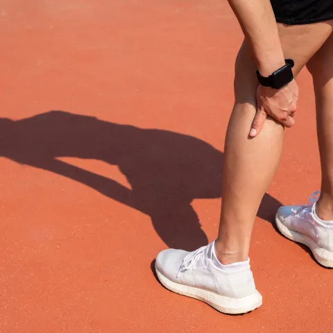 A woman touching her calf, showing concern of injury