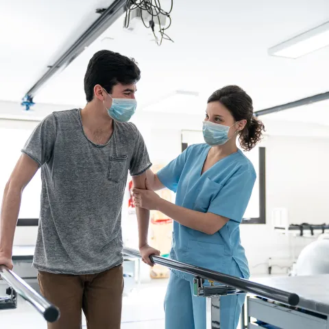 Physical therapist helping a patient through a walking exercise.