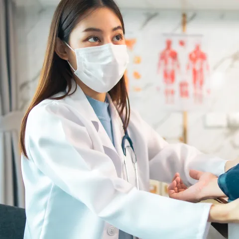 A Doctor Takes a Patient's Blood Pressure with a Blood Pressure Cuff