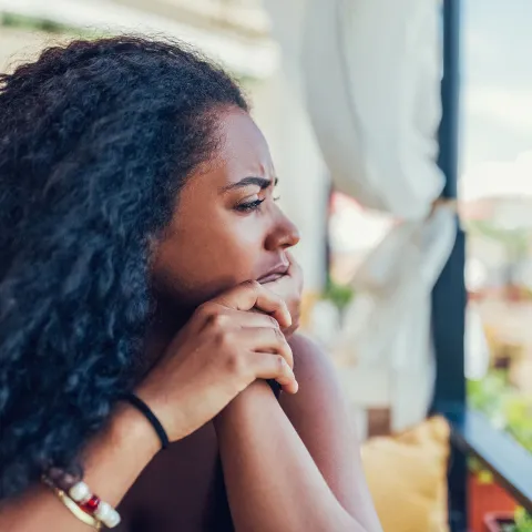 A Woman Stares into the Distance with a Worried Look on Her Face.
