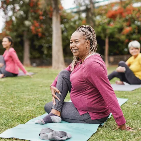 Three Senior Women Stretch in the Park Just Prior to Yoga