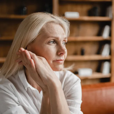 A Woman Thinks Deeply with Her Hand Pressed Against Her Face