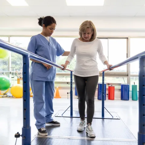 A Female Patient Attends Physical Therapy for Walking with a Therapist
