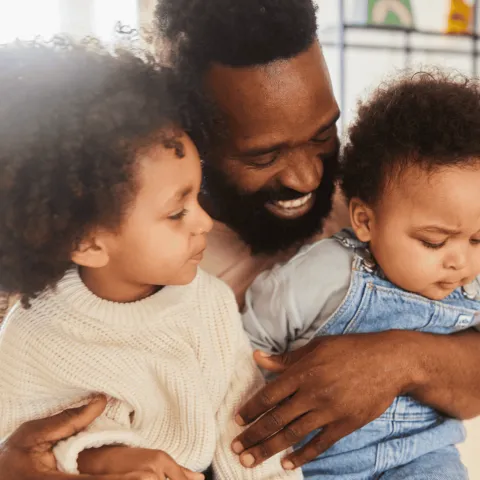 A Father Holds His Two Kids on His Lap