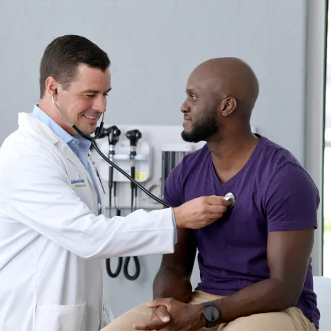 A Provider Checks a Patient's Heart in an Exam Room