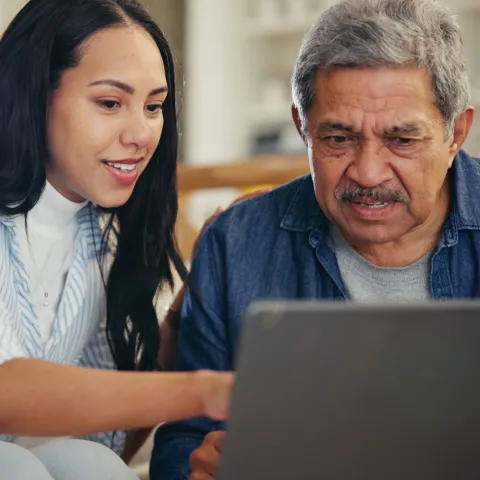 A Daughter Helps Her Senior Father on His Laptop