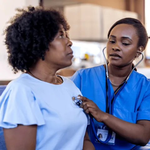 A Provider Listens to a Patient's Heart with a Stethoscope 