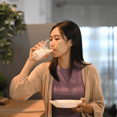 A Woman Drinks a Glass of Milk in Her Kitchen