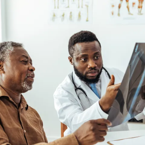 Doctor showing man an X-Ray of his lungs