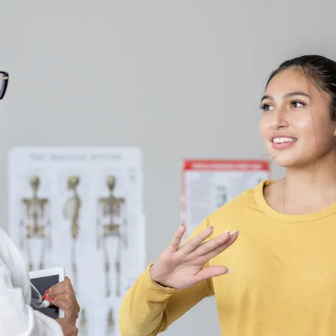 A young woman talking to her doctor.