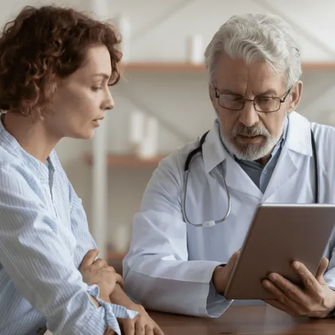 A Provider Goes Over a Patient's Chart with Her on a Tablet.