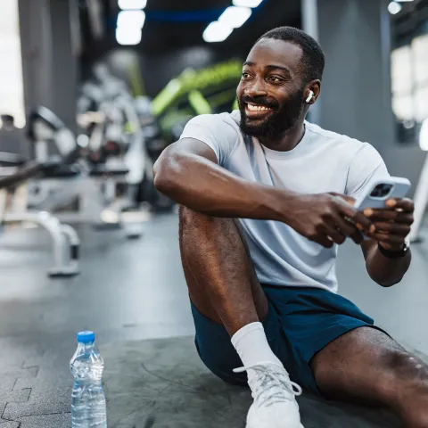 A man taking a break from a workout at the gym.