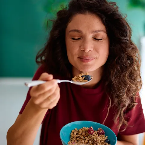 A woman eating cereal.