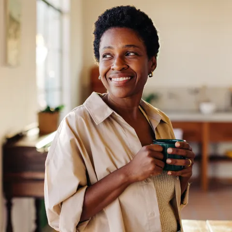 Woman smiling holding a cup of coffee