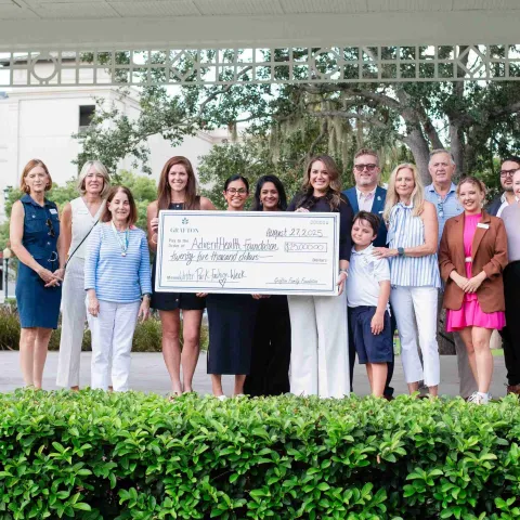 Group of people holding large check