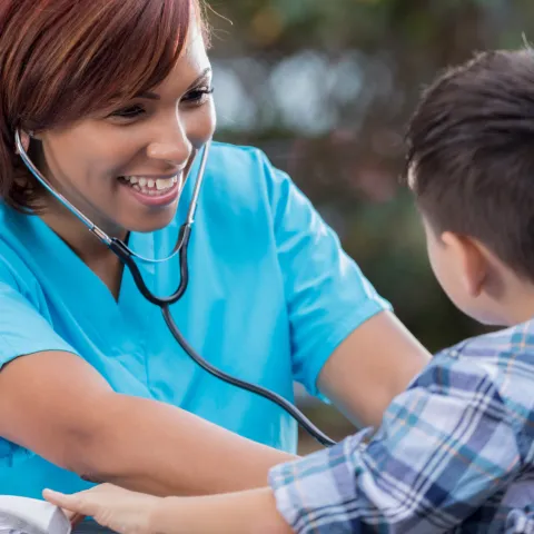 Nurse Listening to Boy's Heartbeat