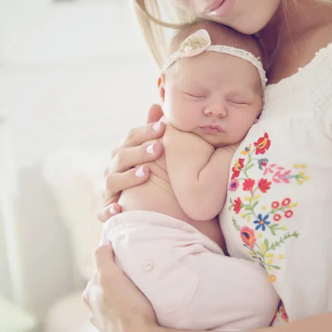 Mother holding baby to her chest.