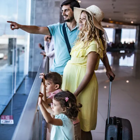 A family watches planes at the airport together.