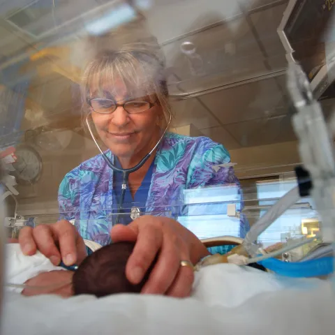 Nurse tending to a baby in the NICU.
