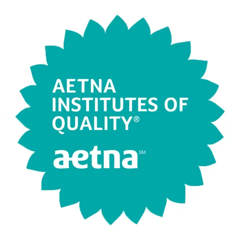 Aetna's circular turquoise badge with sunflower frills around it