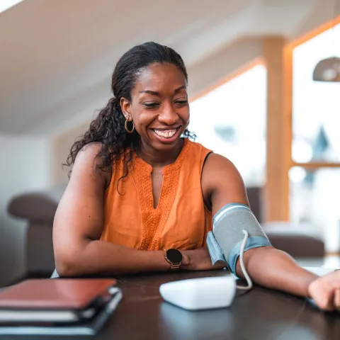 Woman testing blood pressure at home.