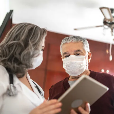 Mature female doctor talking to a male patient