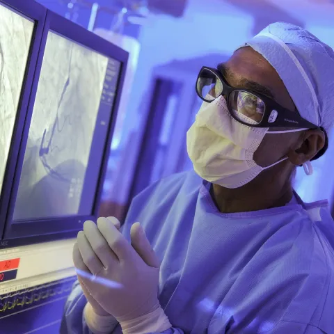 A surgeon at AHS Carrolwood studies a patient's imaging in the operating room, preparing for a procedure