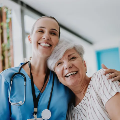Doctor and senior woman patient hugging.