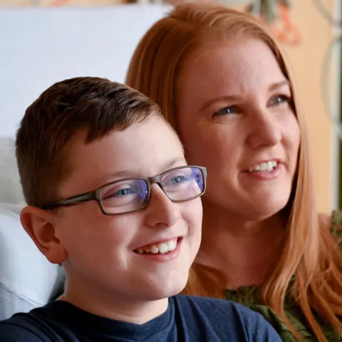 A woman and her son smiling.