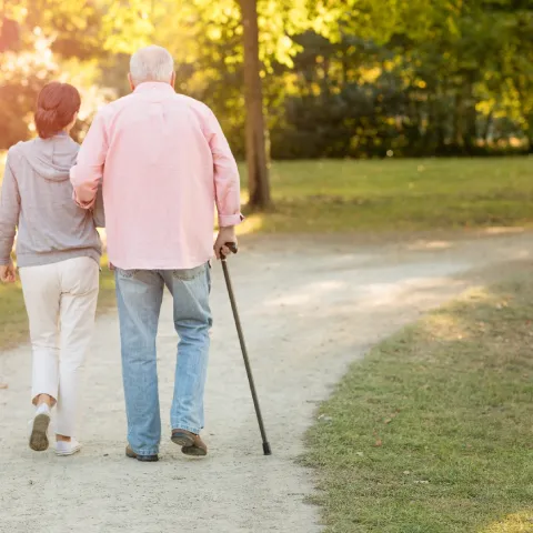 An older couple walking outdoors in the late afternoon