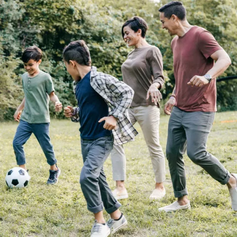 Family playing soccer together at home.