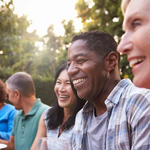Friends sitting outdoors at a table during a dinner party.