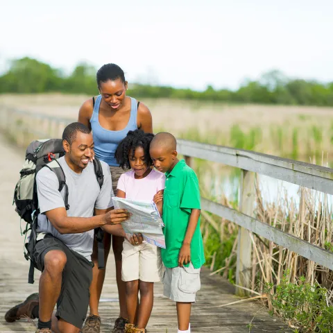 A family walking on a boardwalk together.